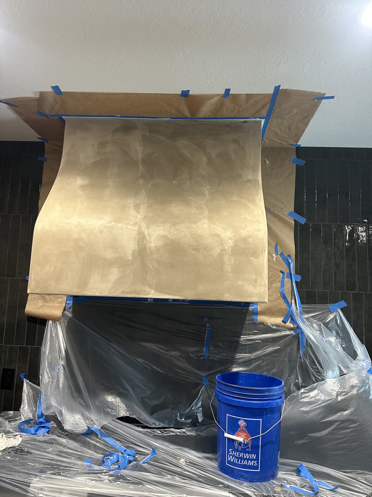 Range hood with a warm tan plaster coat showing hand trowel marks